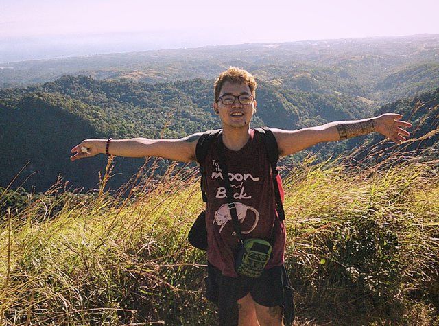 mountain, person, young adult, casual clothing, portrait, lifestyles, looking at camera, leisure activity, standing, smiling, front view, three quarter length, young men, landscape, mountain range, tranquility, grass, happiness