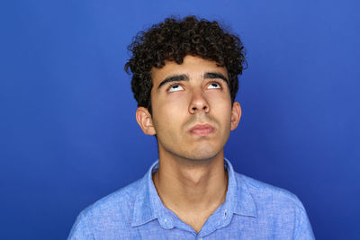 Portrait of young man against blue background