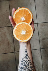 Cropped hand holding oranges