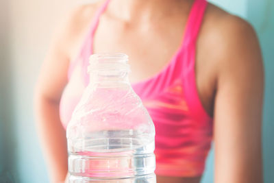 Midsection of woman drinking water glass