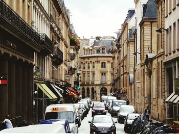 Cars on street in city against sky