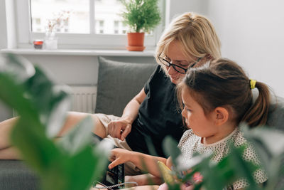 Woman and daughter using digital tablet at home