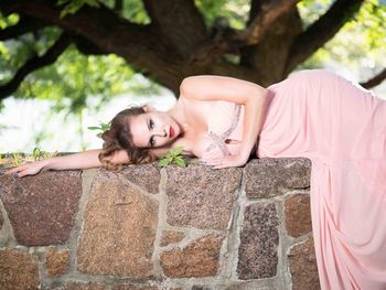 Portrait of young woman against wall