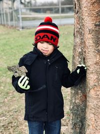 Portrait of boy standing in park during winter