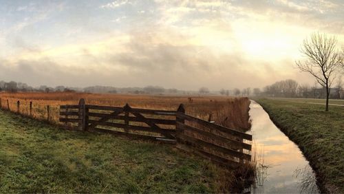 Scenic view of grassy field against cloudy sky