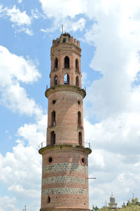 Low angle view of bell tower against cloudy sky