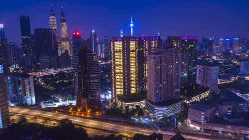 Illuminated buildings in city against sky at night