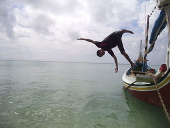 Man surfing in sea against sky