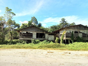 Abandoned house on field against sky