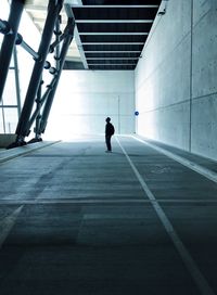 Silhouette man walking on road in city