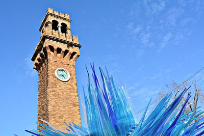 Low angle view of clock tower against blue sky