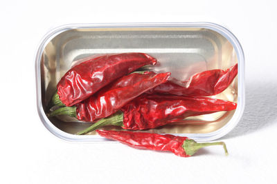 High angle view of red chili peppers on white background