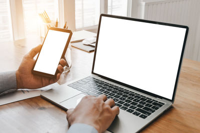 Low section of person using laptop on table