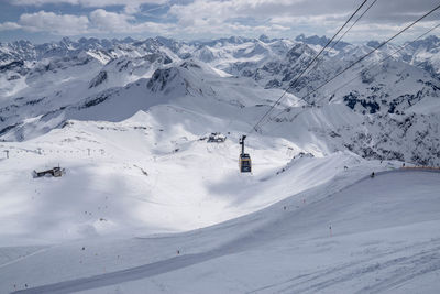 Cable car hanging over snowcapped mountain