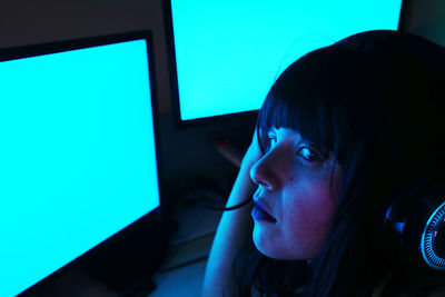 Close-up of woman using computers in darkroom