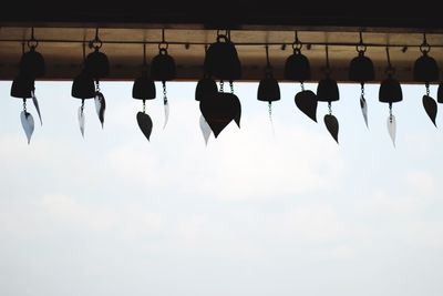 Low angle view of umbrellas hanging against sky