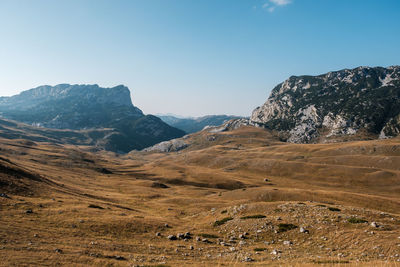 Scenic view of landscape and mountains against clear blue sky