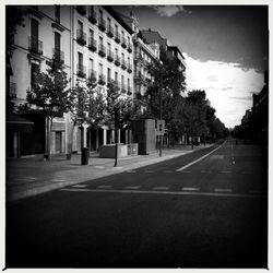 Empty road along buildings