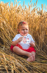 Portrait of young woman sitting on field