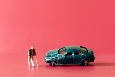 Toy car against pink background