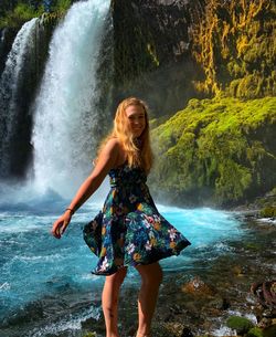 Full length of young woman standing on rock