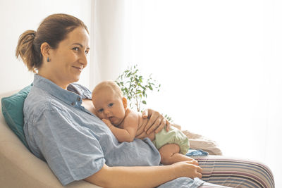 Side view of couple sitting on sofa at home