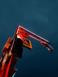 Low angle view of illuminated traffic lights  against blue sky