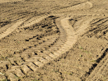 High angle view of tire tracks on field