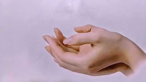 Close-up of hand over white background