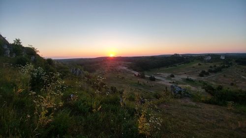 Scenic view of landscape against clear sky during sunset