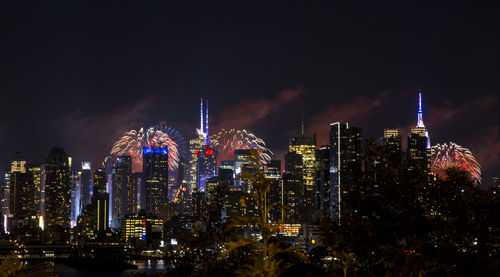 Illuminated cityscape against sky at night