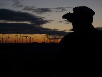 Silhouette man standing against sky during sunset