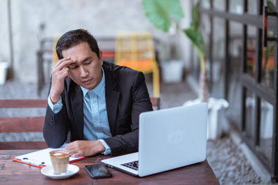 Businesswoman using laptop while sitting on table