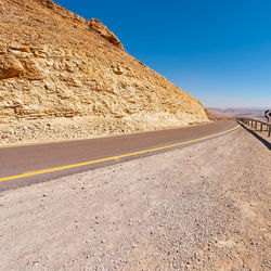 Road by mountain against clear sky