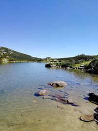 Scenic view of lake against clear blue sky