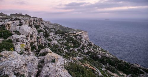 Scenic view of sea by mountains against sky