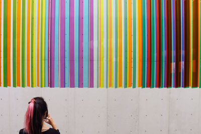 Rear view of woman looking at colorful patterned wall