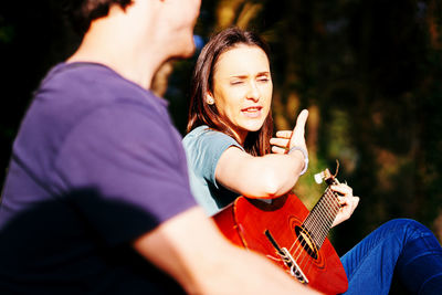 Midsection of man with woman sitting outdoors