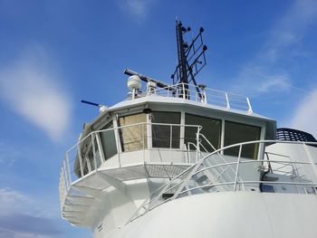 Low angle view of a ship bridge against blue sky