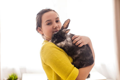 Portrait of man holding cat against white background