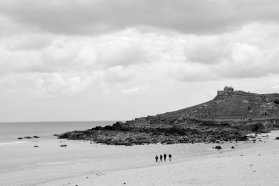 Group of people on beach against sky