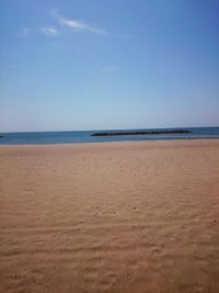 Scenic view of beach against blue sky