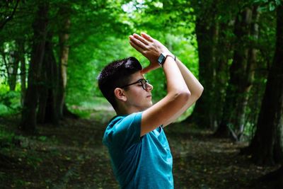 Side view of young woman in forest