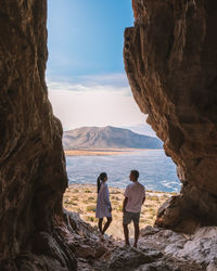 Rear view of people looking at sea against sky