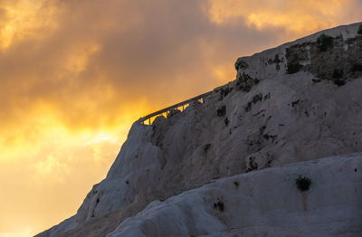 Low angle view of snowcapped mountain against sky during sunset