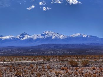 Scenic view of snowcapped mountains against blue sky