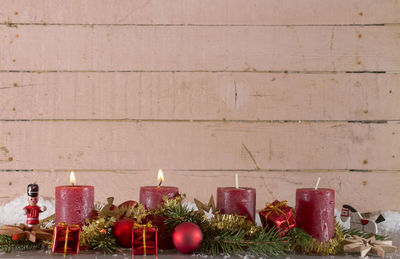 Close-up of candles with christmas decorations on table