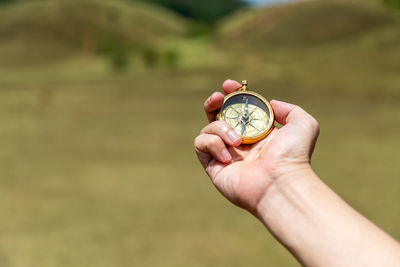 Close-up of person holding hand on field