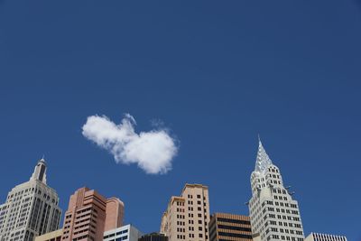 Low angle view of skyscrapers against blue sky