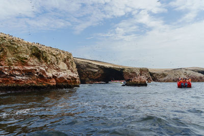 Rock formation by sea against sky